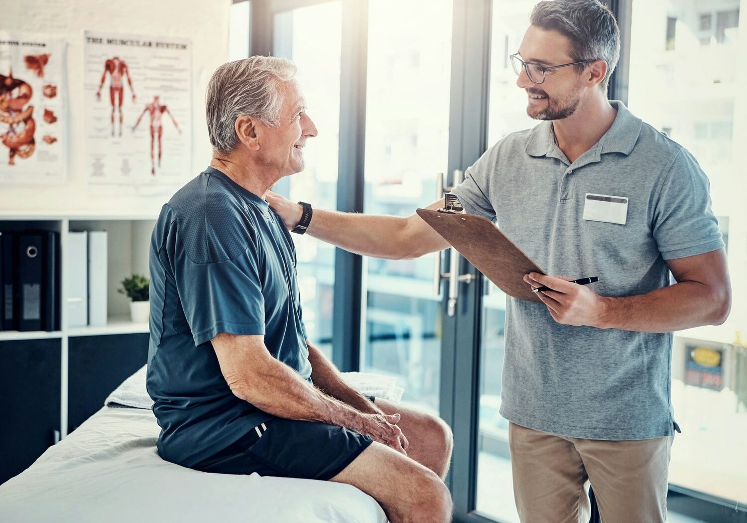 Chiropractor greeting and consulting male patient before starting therapy.