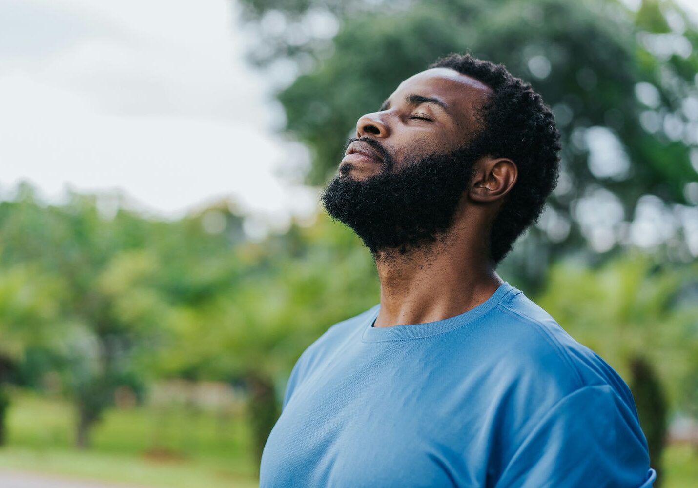 Man practicing deep breathing outside to support mental health and stress reduction.