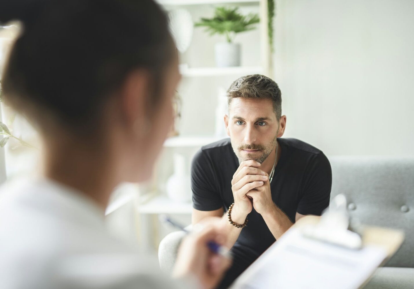 Therapist listening to a male client during an individual psychotherapy appointment.