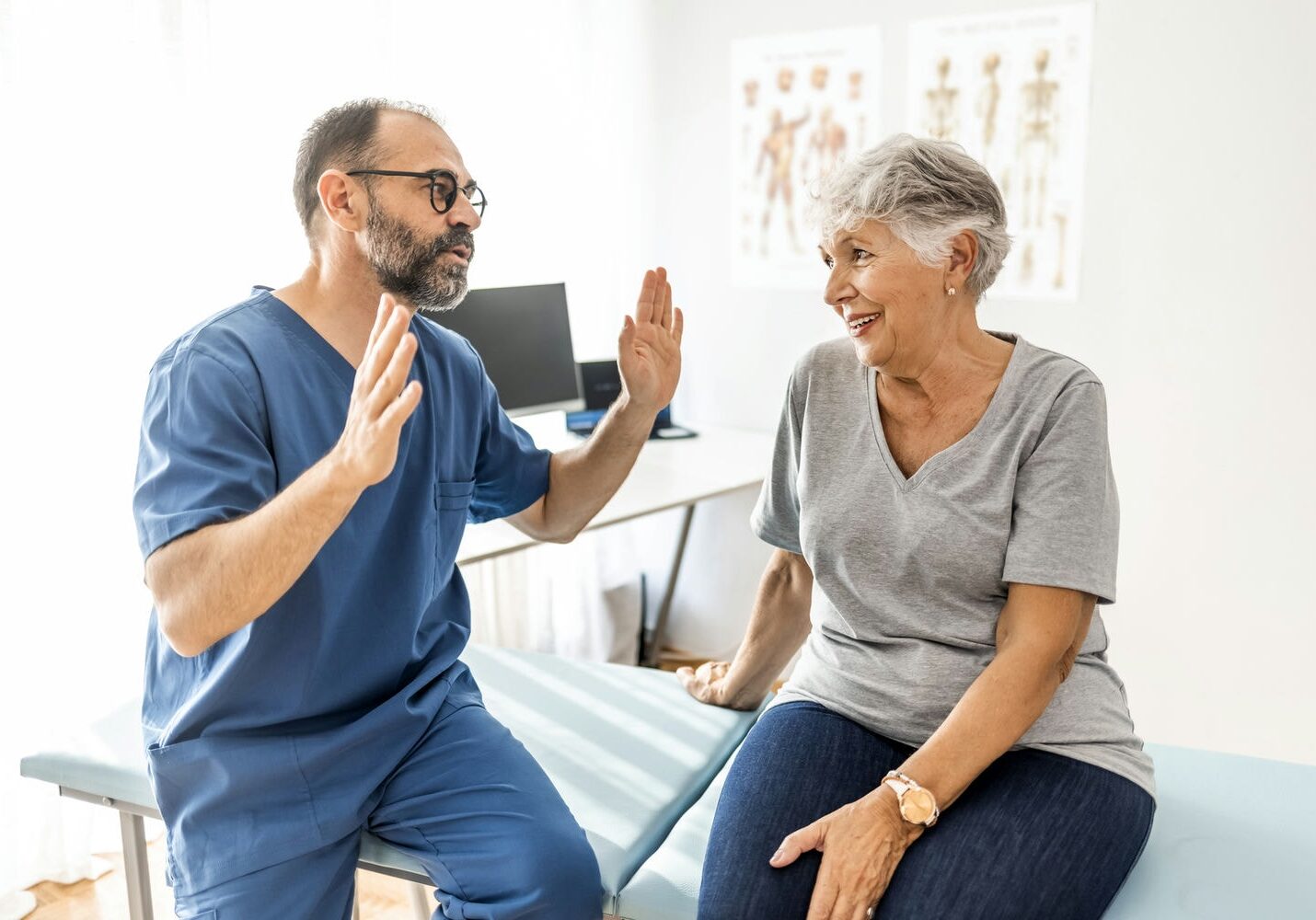Physiotherapist discussing symptoms and goals with an older woman during an initial consult.