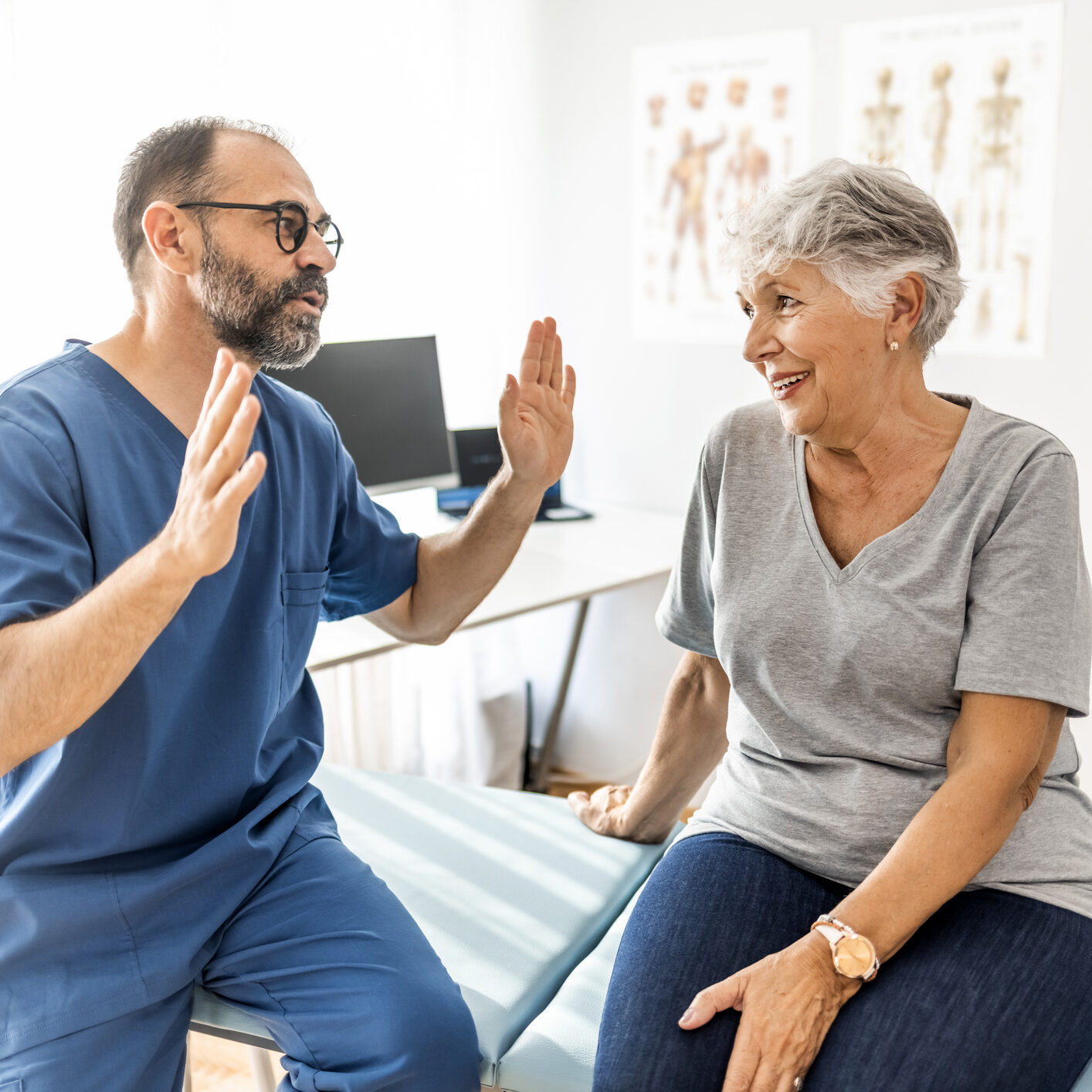 Cropped shot of a handsome mature male physiotherapist doing a consultation and assessment with a senior female patient.