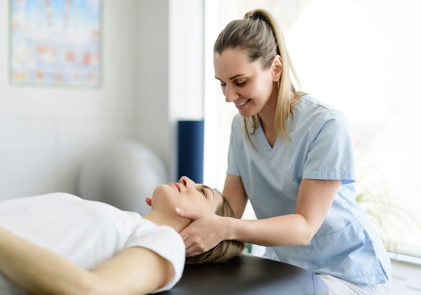 Therapist gently massaging a client’s neck as they rest on the table.