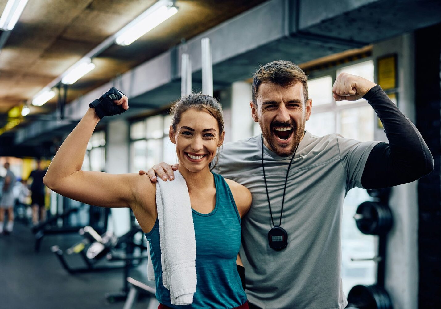 Two athletes celebrating progress in the gym after completing a sports rehabilitation program.