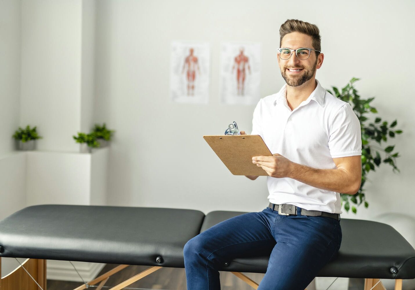 Massage therapist seated with a clipboard, planning a personalized treatment.