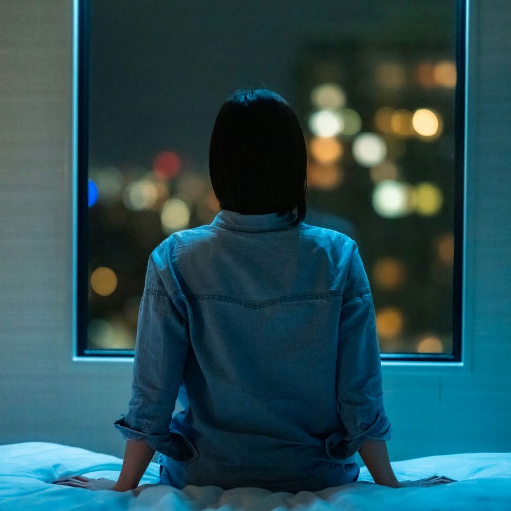 woman sitting on the edge of a bed because she cant sleep